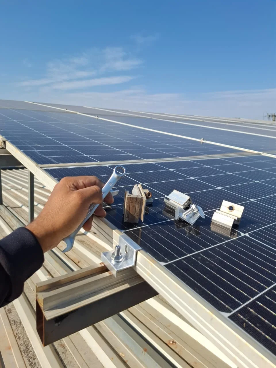 Profissional realizando manutenção na estrutura de fixação de um painel solar